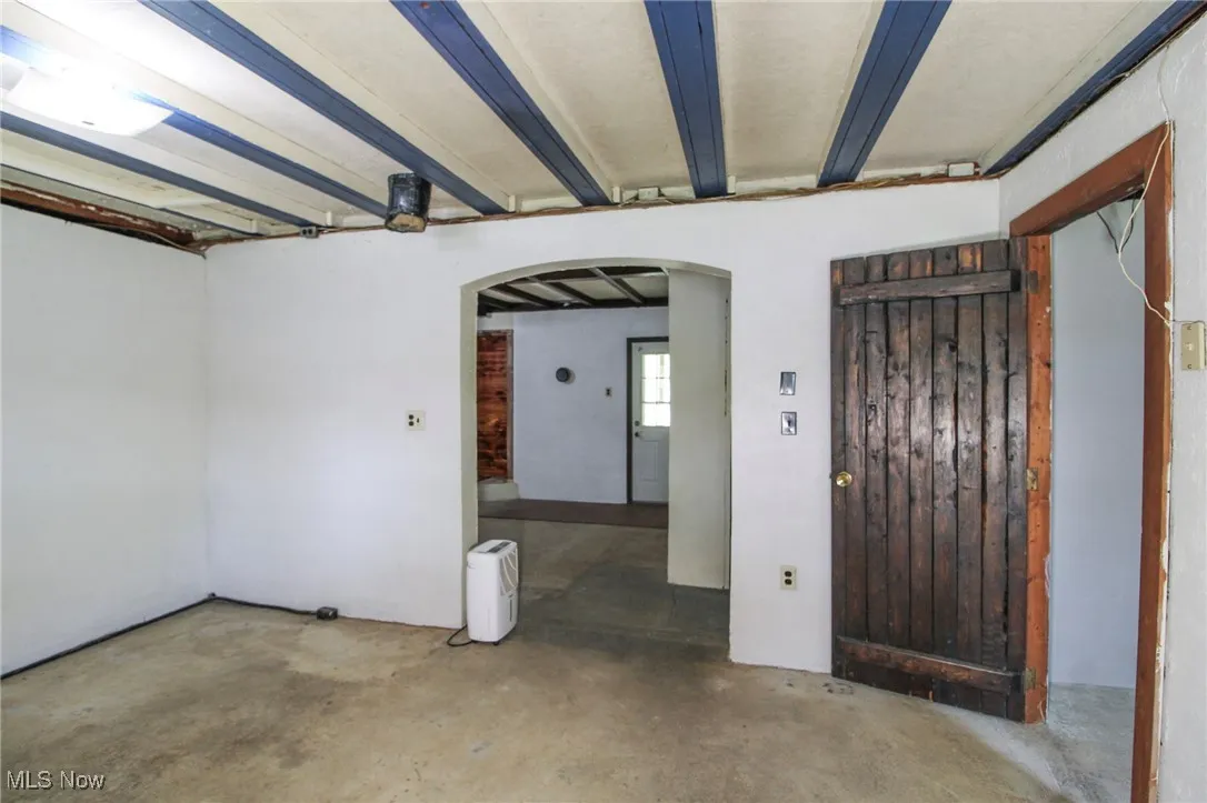 Foyer entrance featuring arched walkways and unfinished concrete floors