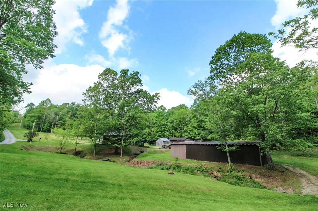 View of green lawn featuring an outbuilding