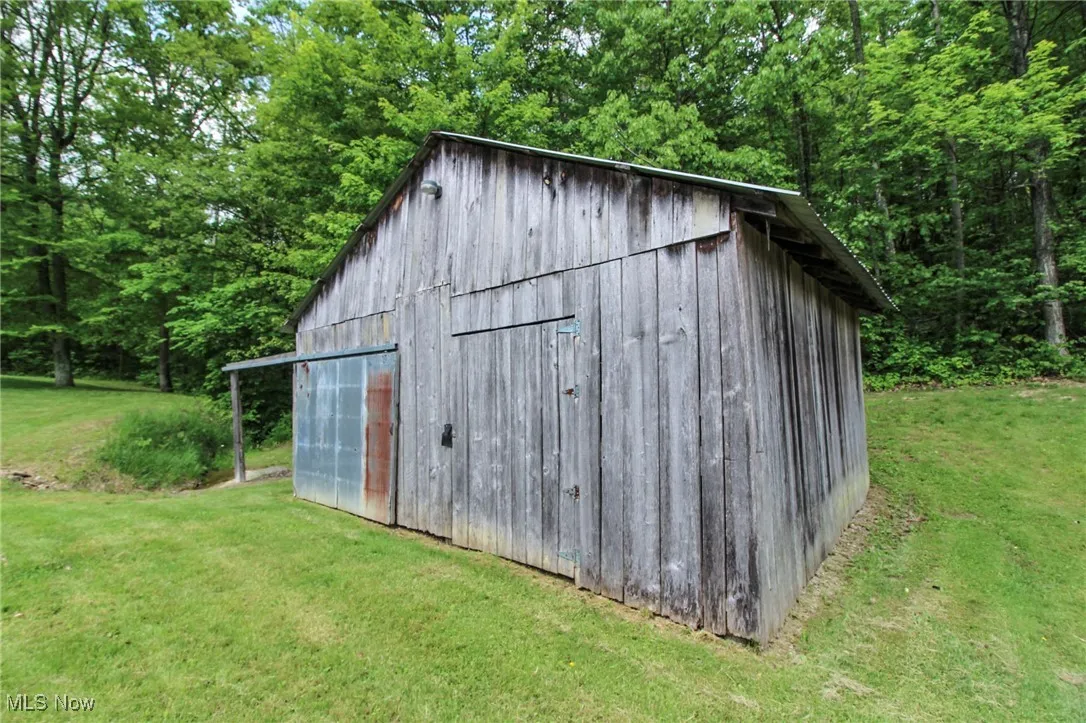 View of outdoor structure with an outbuilding and a forest view