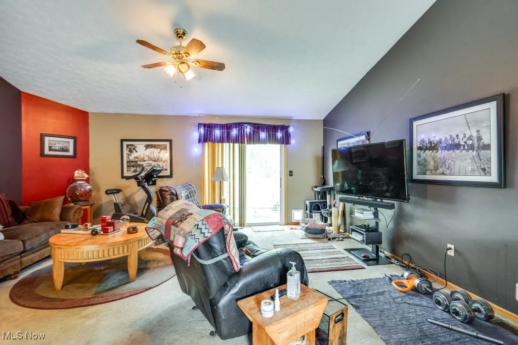 Carpeted living area with a ceiling fan