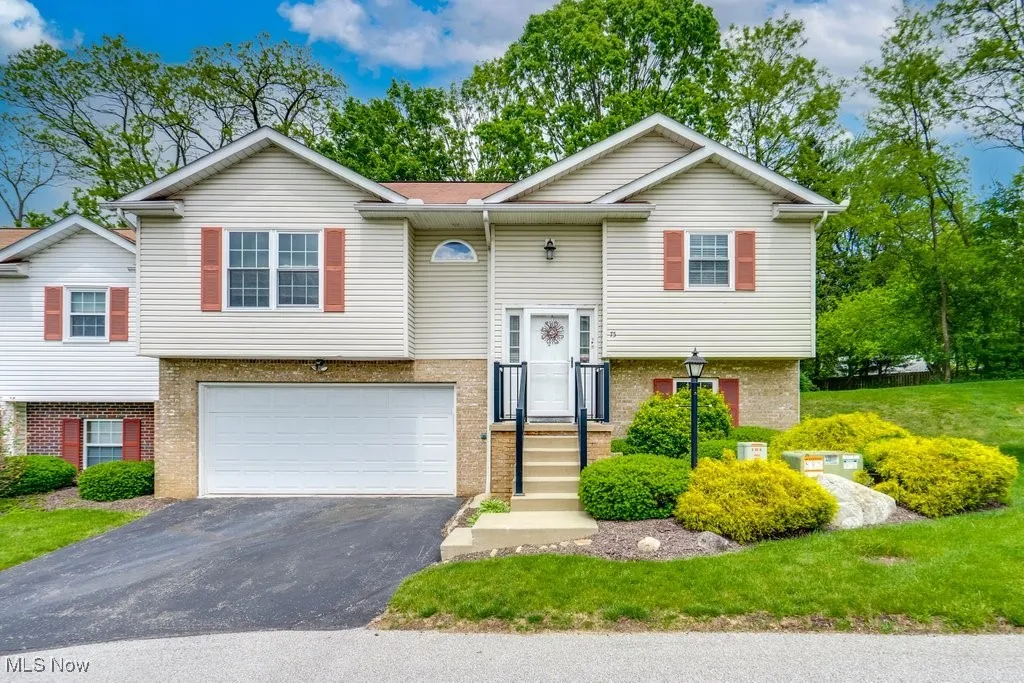 75 River Run Ln: Bi-level home with driveway, a garage, and brick siding