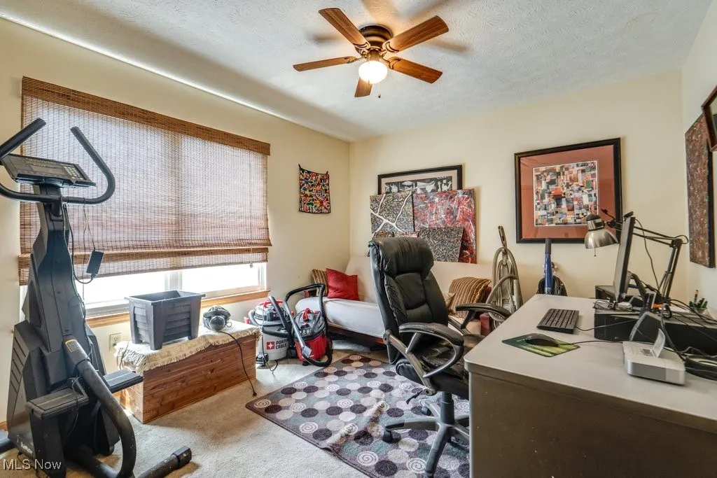 Bedroom (being used as office) featuring carpet floors, ceiling fan, and a textured ceiling