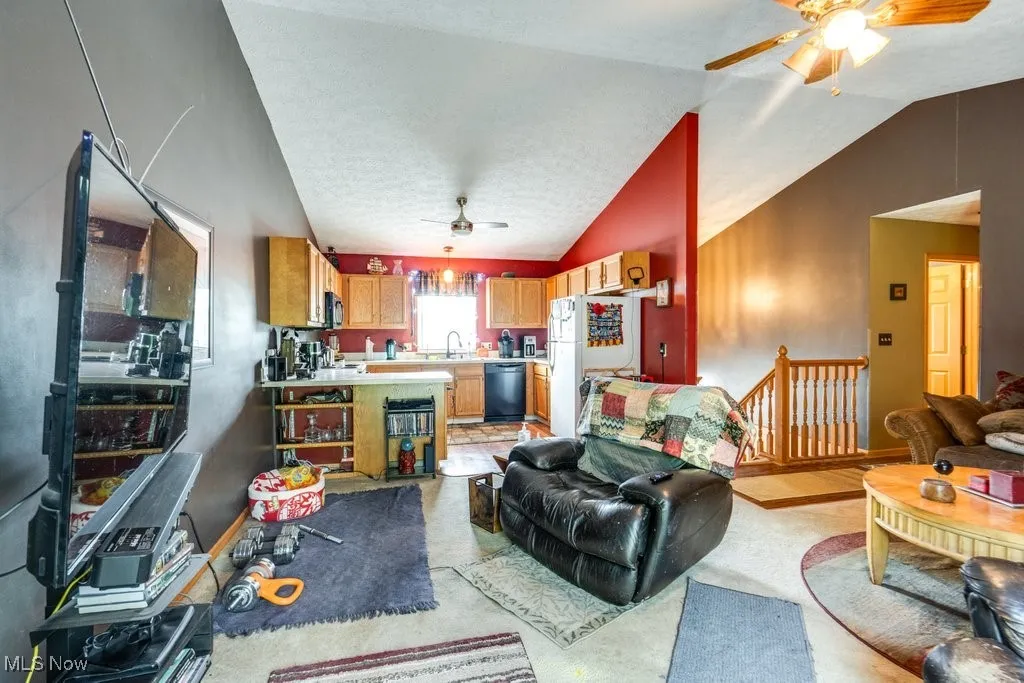 Living area with a ceiling fan and lofted ceiling