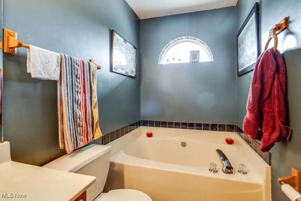 Bathroom with a garden tub, toilet, and vanity