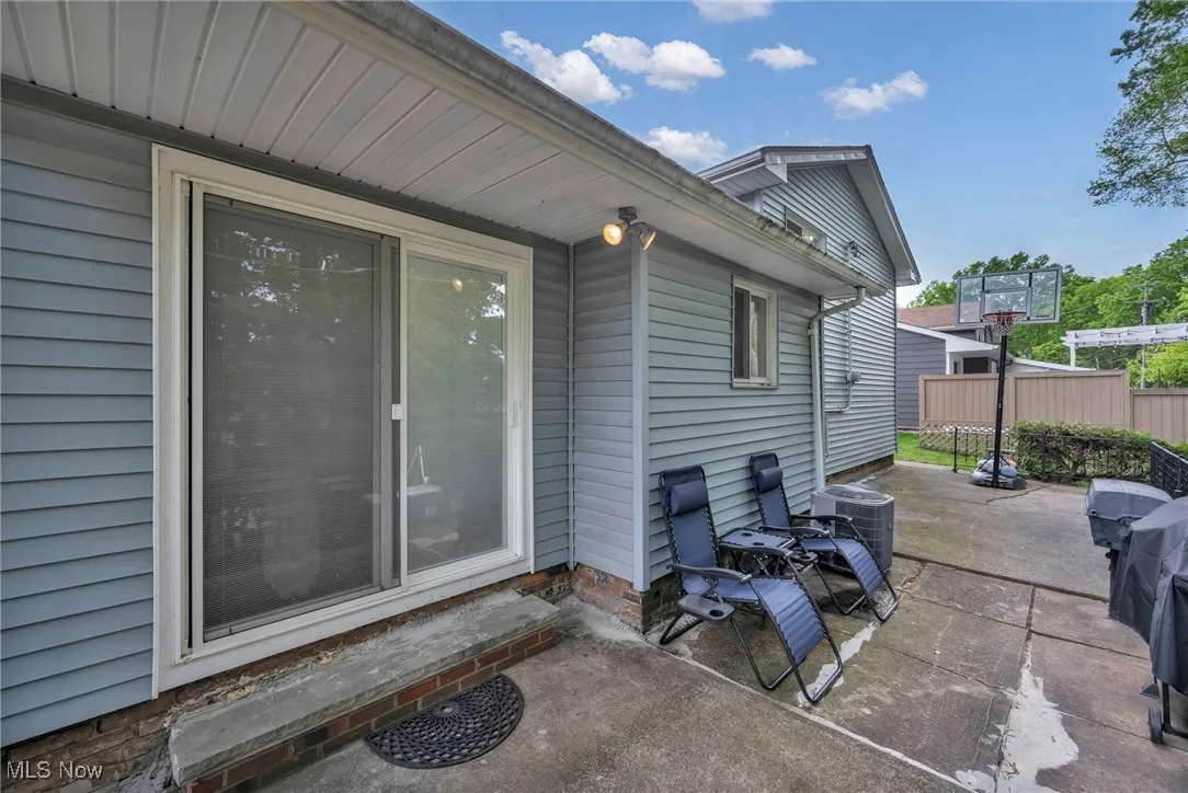 View of patio featuring fence and cooling unit