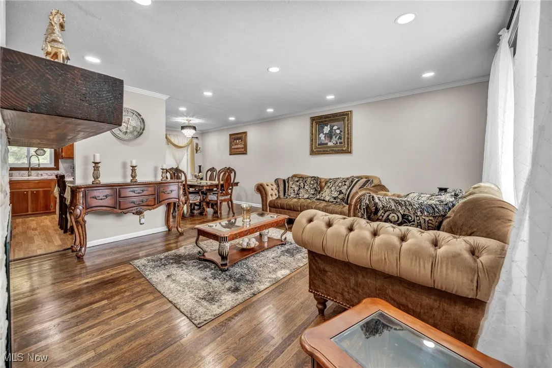 Living area featuring ornamental molding, recessed lighting, wood finished floors, and baseboards