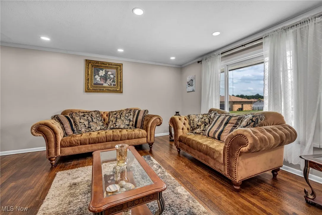 Living area with ornamental molding, baseboards, wood finished floors, and recessed lighting