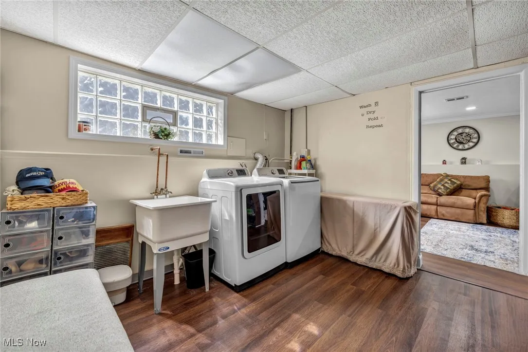 Laundry area featuring washing machine and clothes dryer and dark wood-type flooring