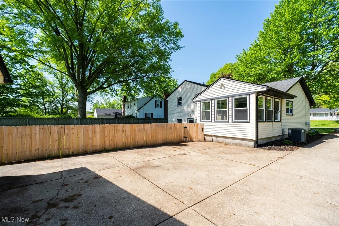 View of side of property with central air condition unit and fence
