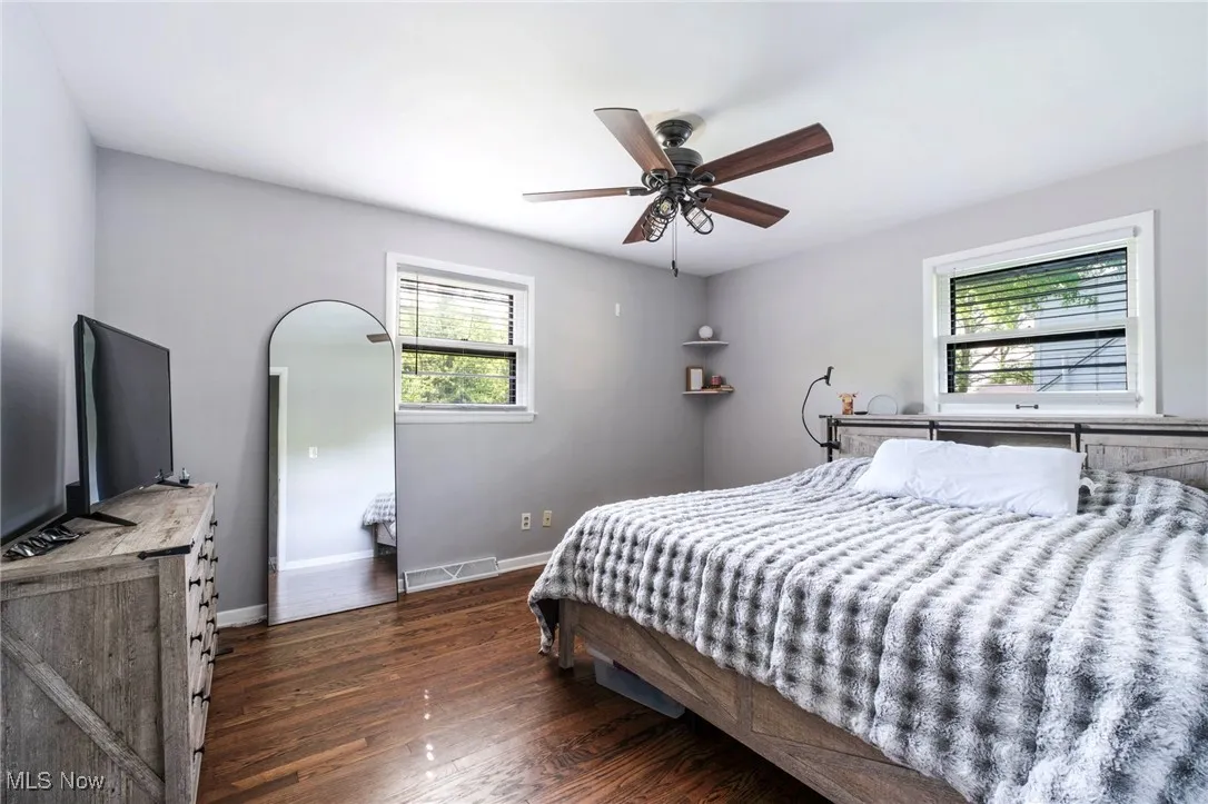 Bedroom with dark wood-type flooring, baseboards, and a ceiling fan
