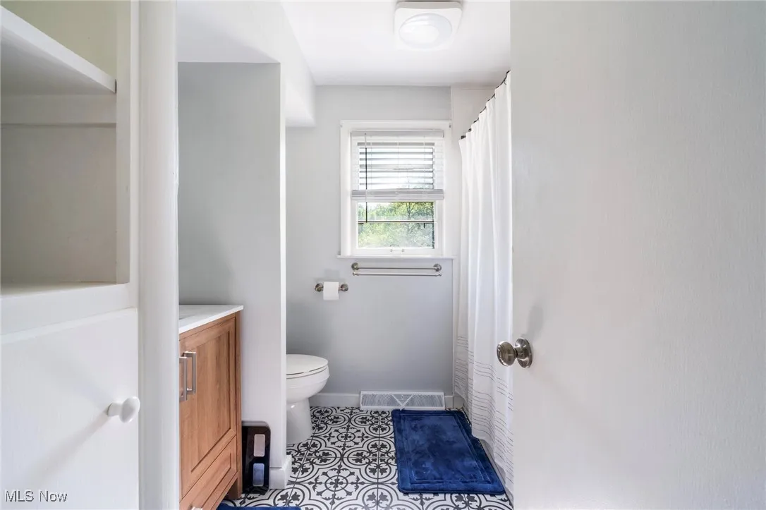 Full bath featuring toilet, tile patterned flooring, vanity, and baseboards
