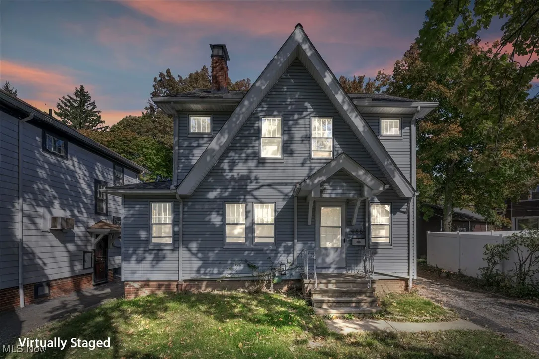 View of front of home with a chimney and fence