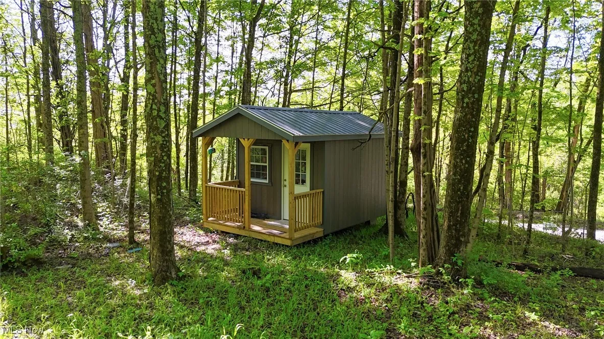 View of outdoor structure featuring an outbuilding and a forest view