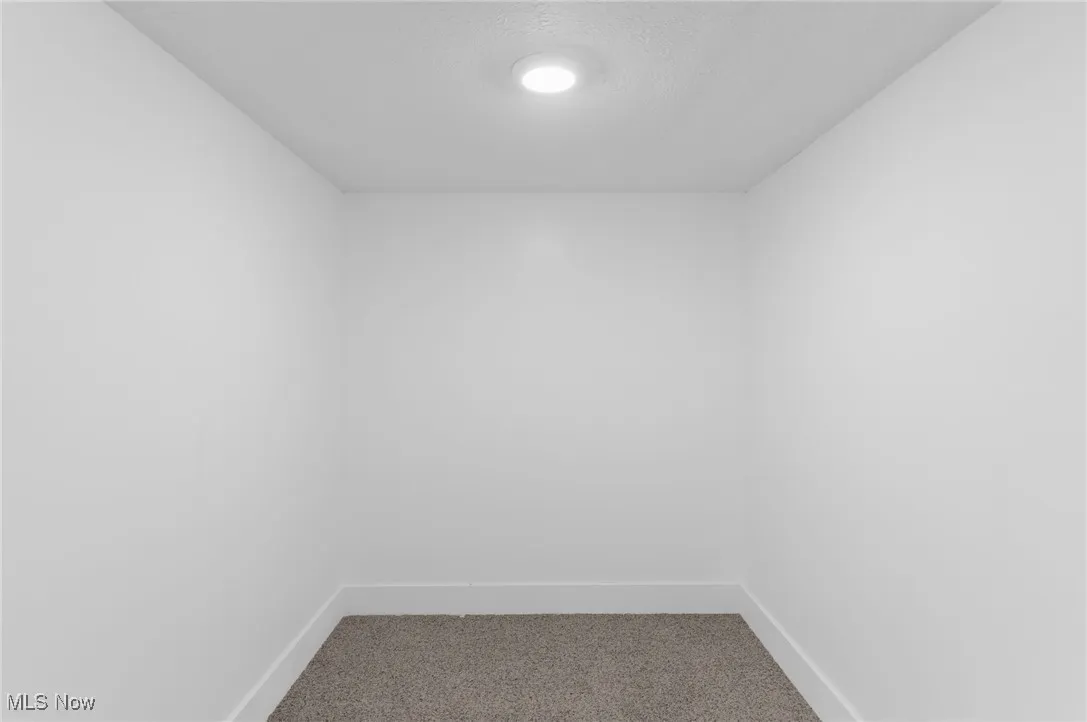 Carpeted empty room featuring baseboards
