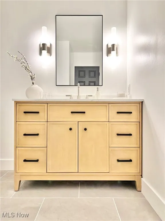 Bathroom featuring tile patterned floors, vanity, and baseboards