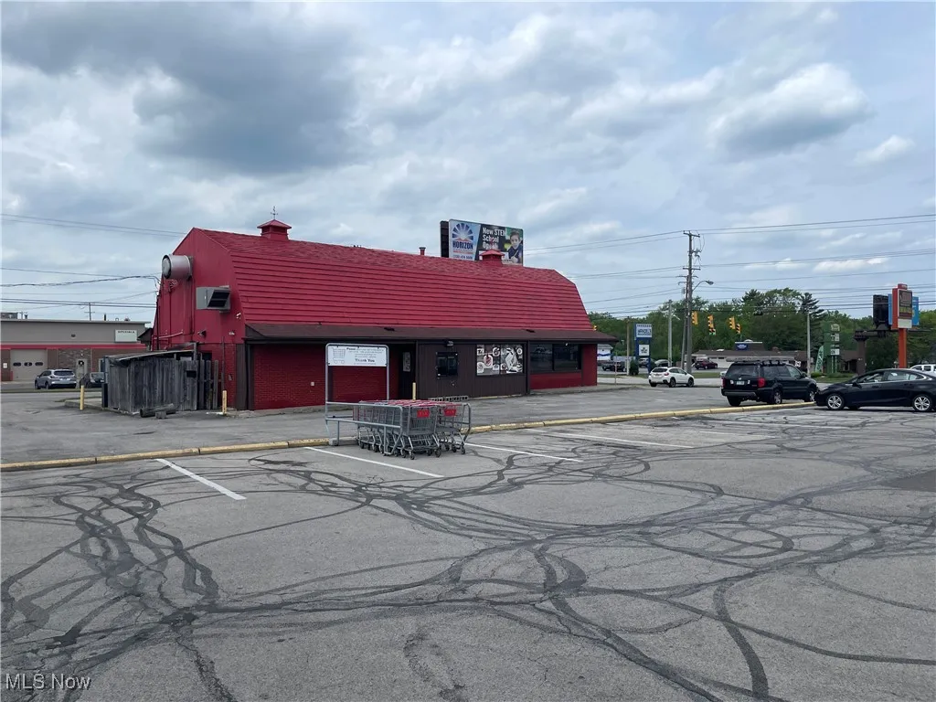 View of building exterior featuring uncovered parking