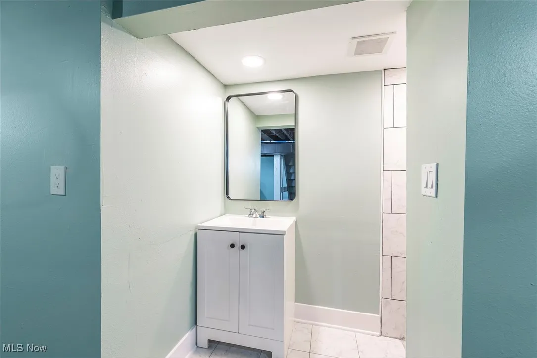 Bathroom with baseboards, vanity, and tile patterned flooring