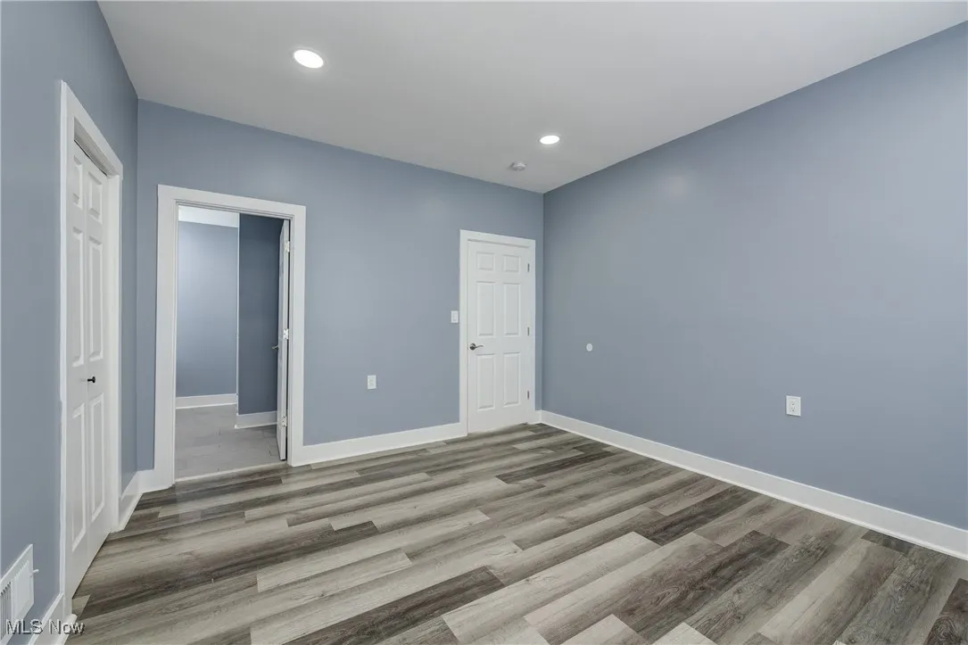 Unfurnished bedroom with baseboards, wood finished floors, a closet, and recessed lighting
