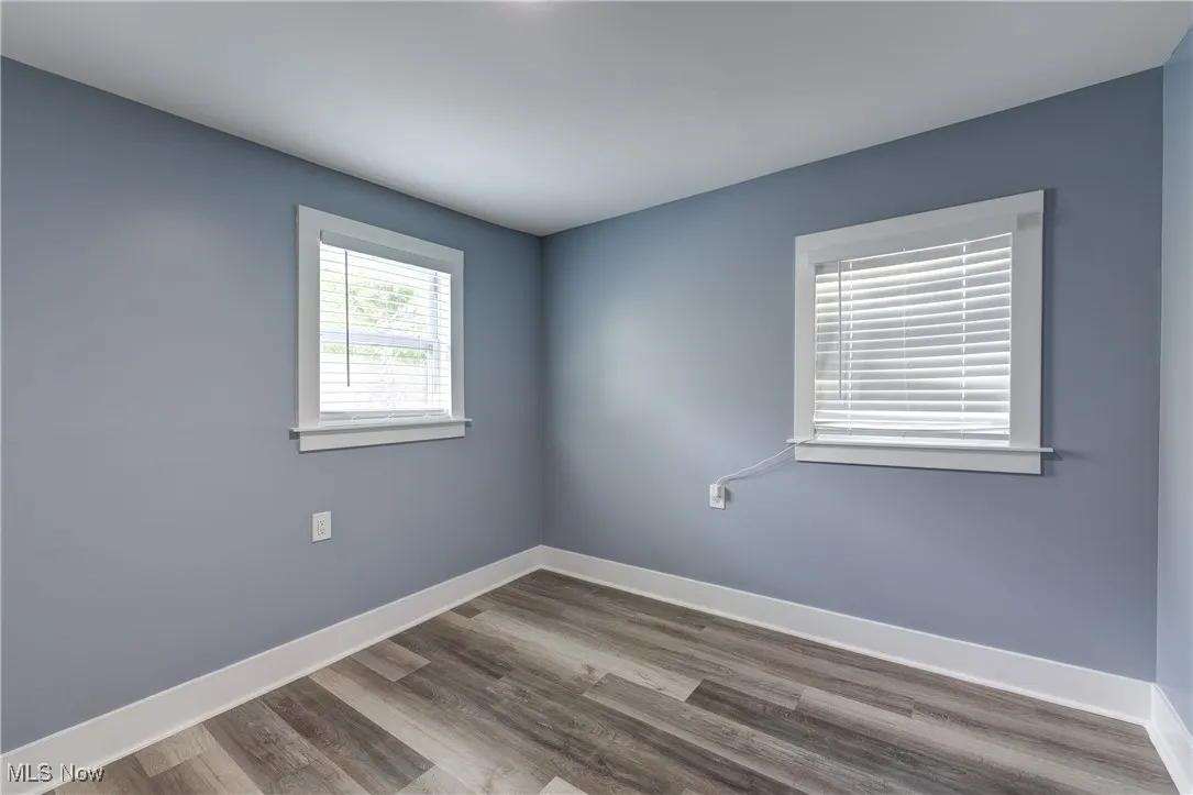 Unfurnished room featuring baseboards and wood finished floors