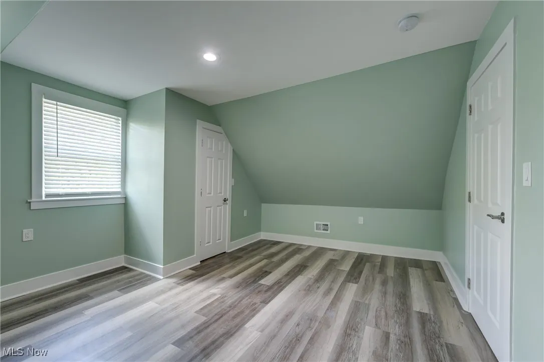 Bonus room with vaulted ceiling, wood finished floors, baseboards, and recessed lighting