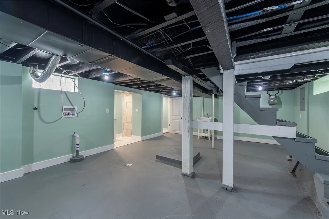 Finished basement with baseboards, stairway, and gas meter
