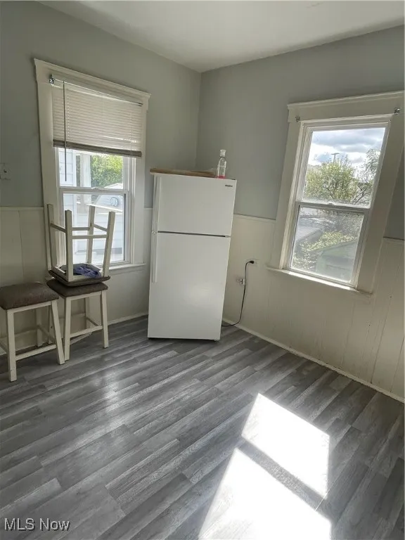 Dining space with wood finished floors and wainscoting