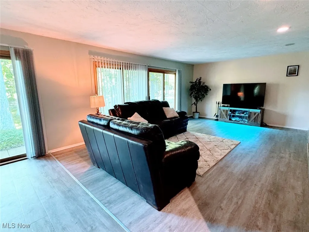 Living area with wood finished floors, baseboards, and a textured ceiling