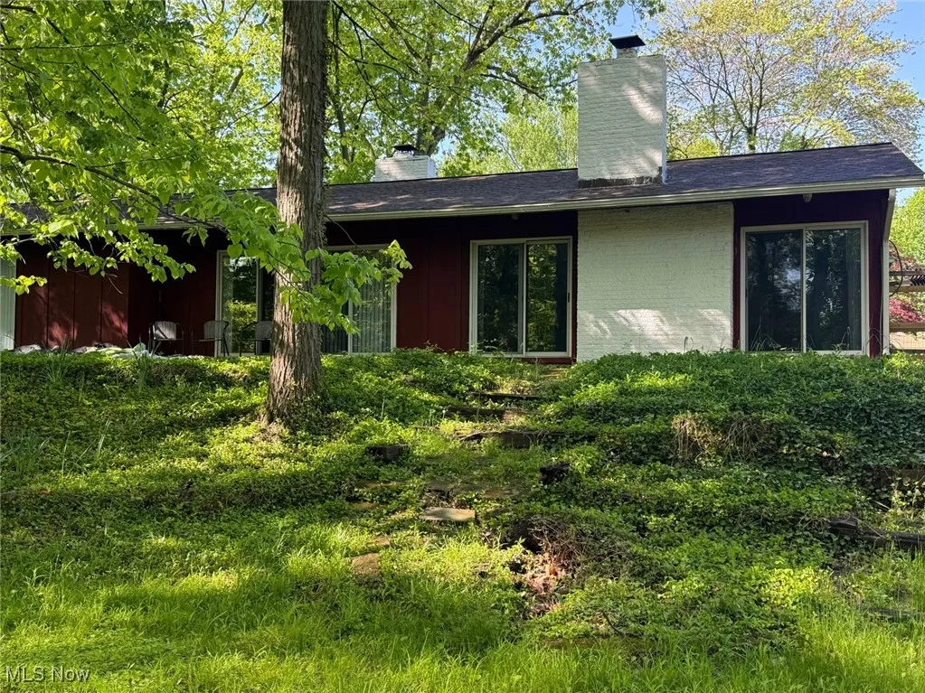 View of home's exterior featuring a chimney and brick siding