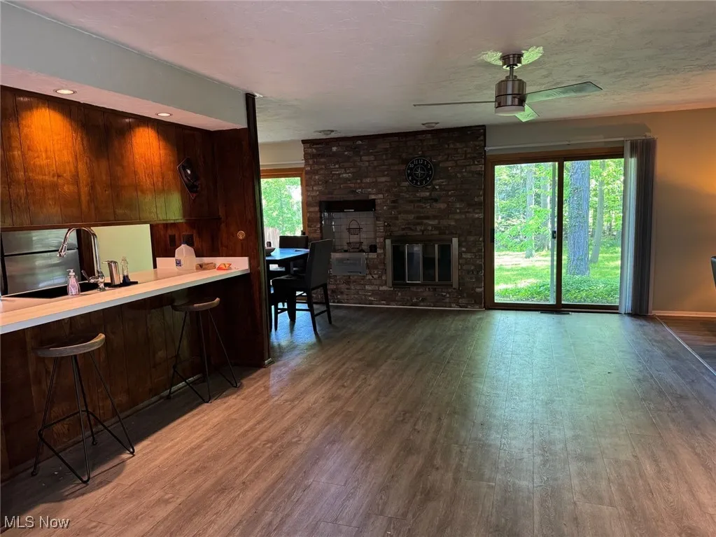 Kitchen with a ceiling fan, wood finished floors, and a sink