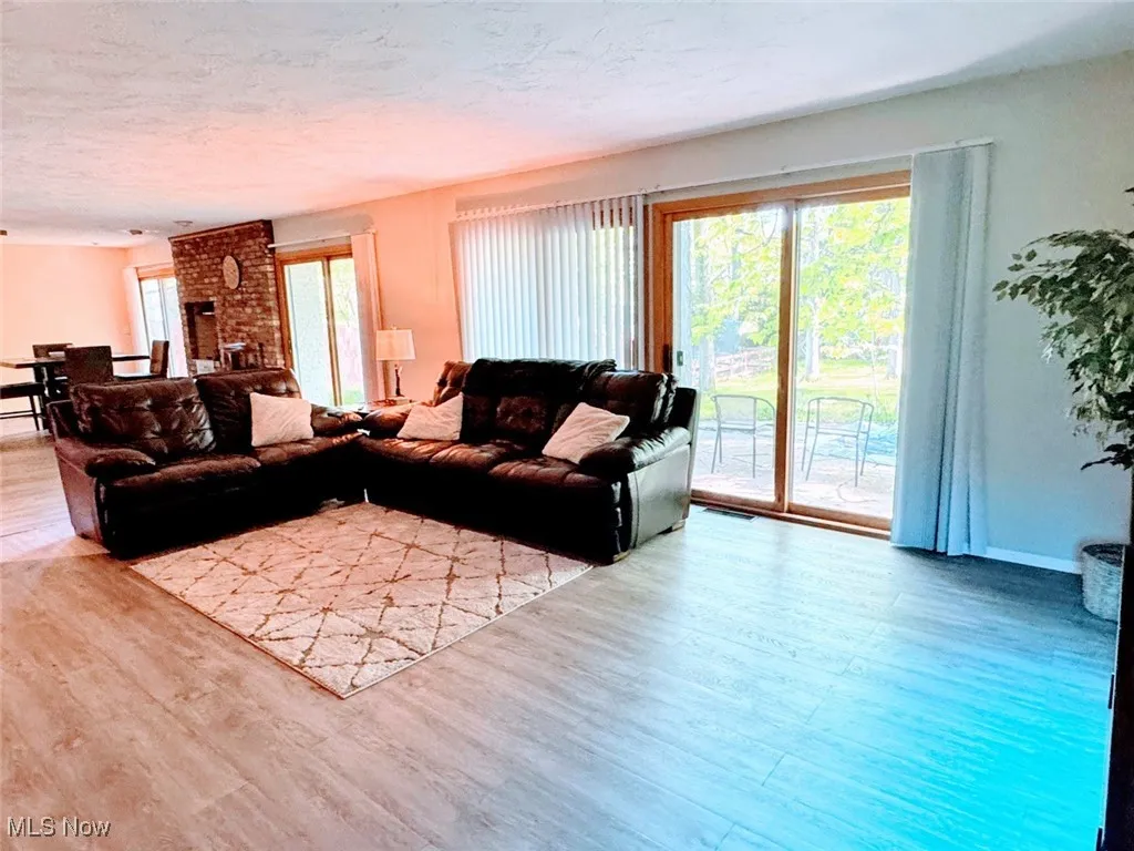 Living room with wood finished floors, plenty of natural light, a textured ceiling, and baseboards