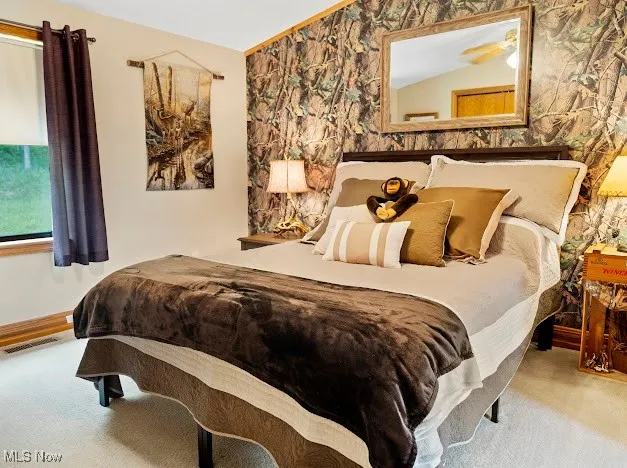 Carpeted bedroom with wallpapered walls and baseboards