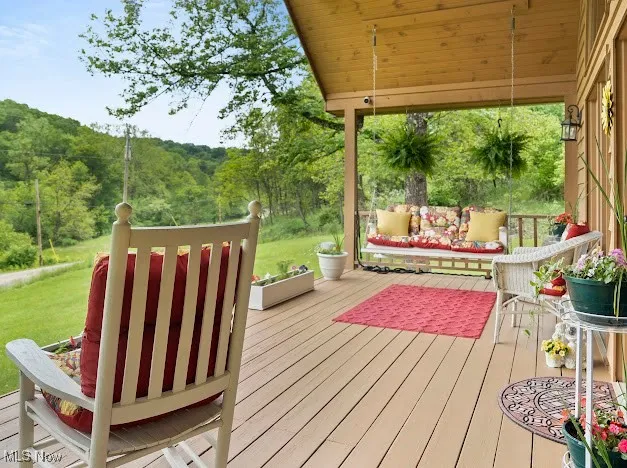 Wooden deck with a wooded view and a lawn