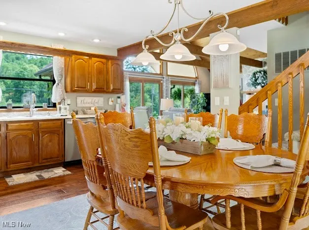 Dining area with dark wood-type flooring, healthy amount of natural light, stairs, and recessed lighting