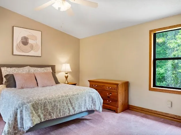 Bedroom with carpet floors, baseboards, a ceiling fan, and vaulted ceiling