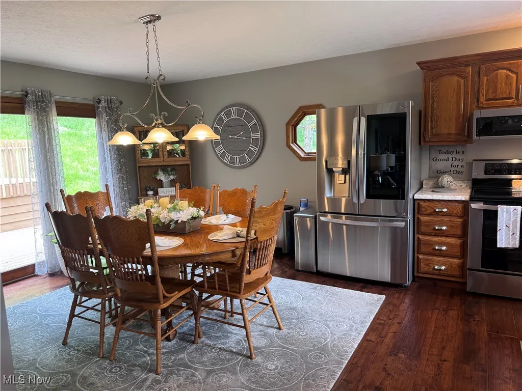 Dining space with dark wood finished floors and a chandelier