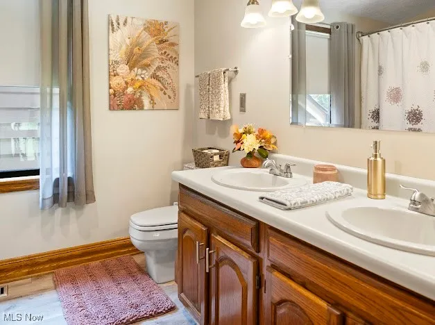 Full bathroom with toilet and double vanity