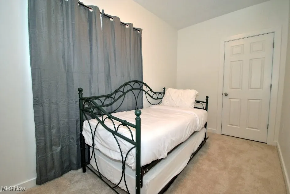 Bedroom featuring light colored carpet and baseboards