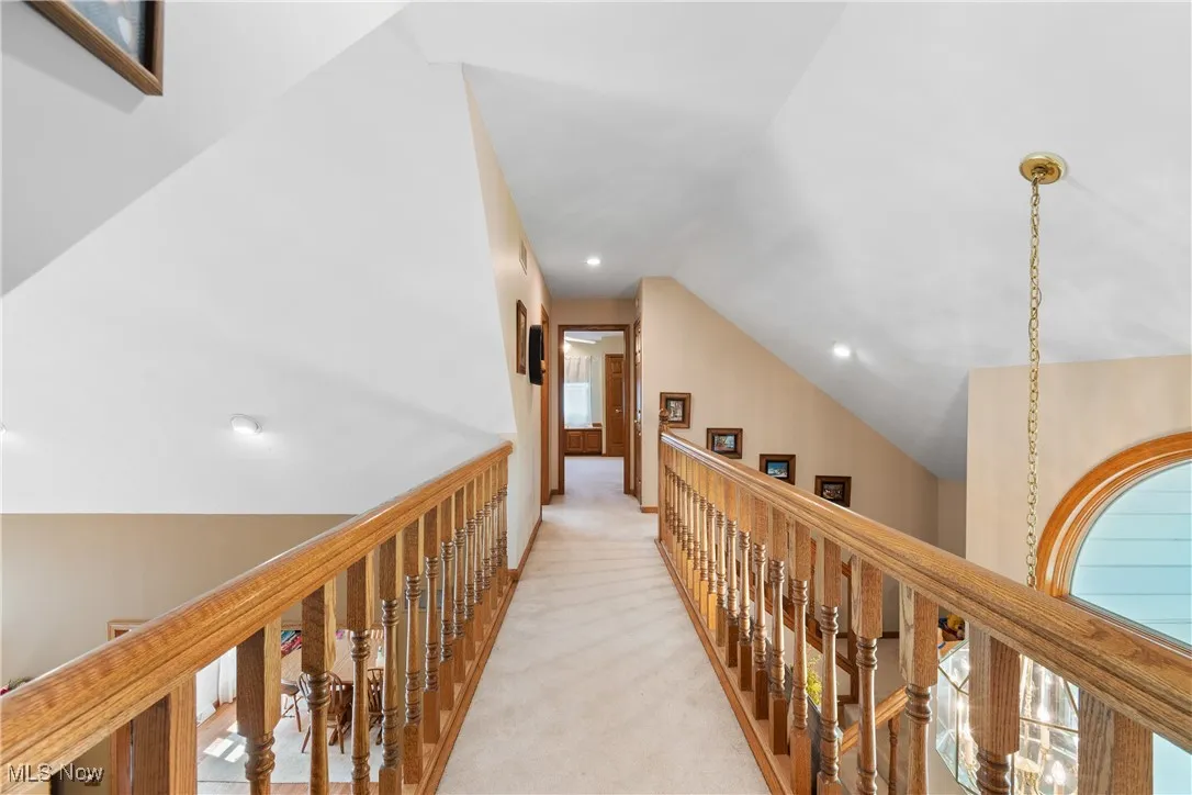 Corridor featuring lofted ceiling, light carpet, an upstairs landing, and recessed lighting