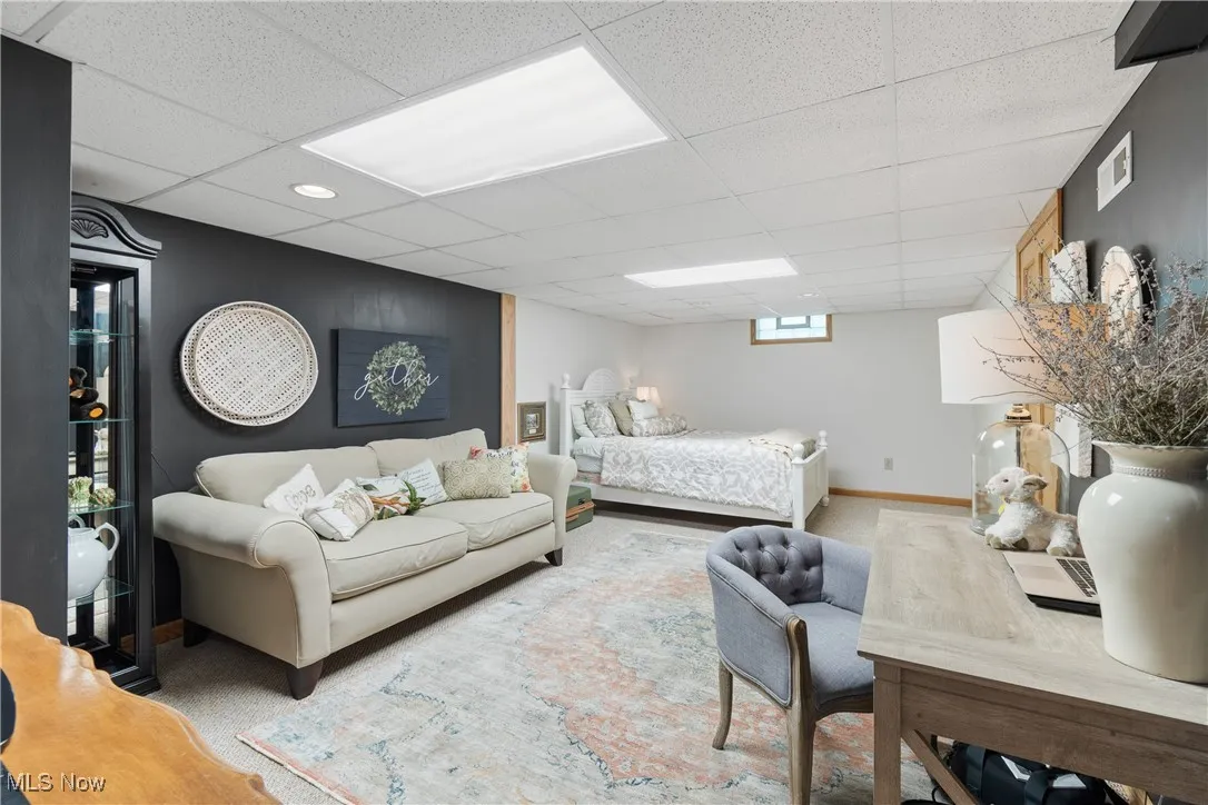 Carpeted bedroom with a paneled ceiling and baseboards