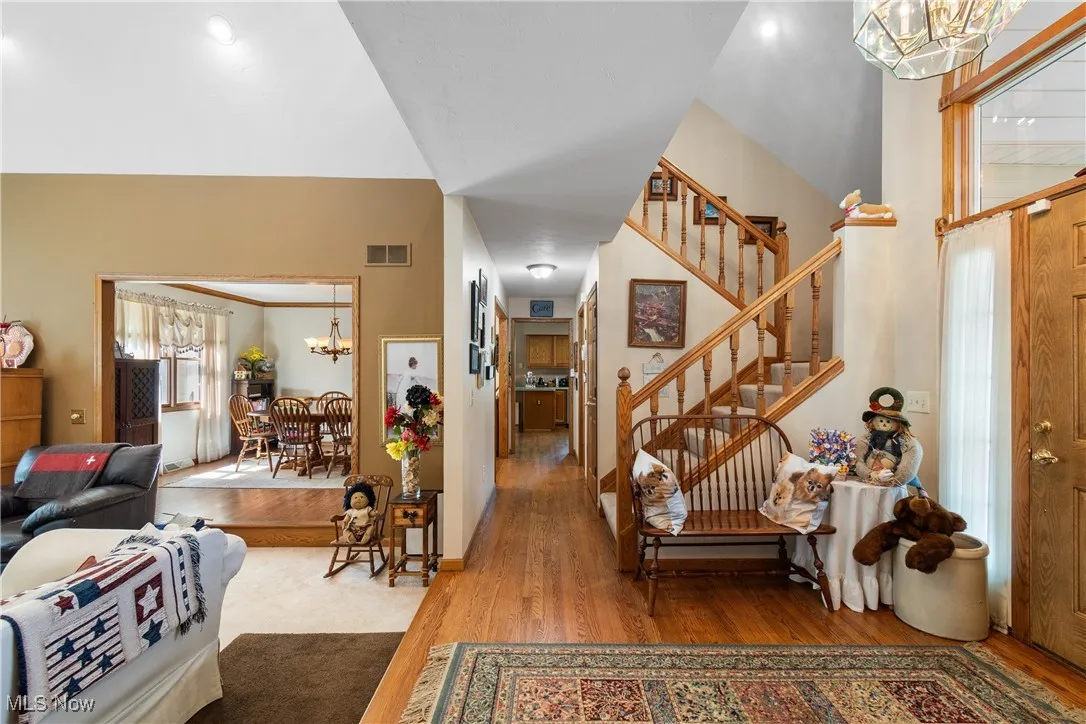 Foyer with a chandelier, wood finished floors, stairs, and baseboards