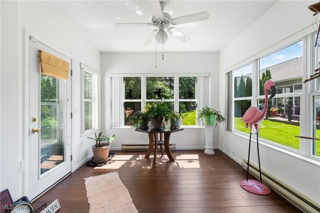 Sunroom with wood-type flooring and a baseboard radiator