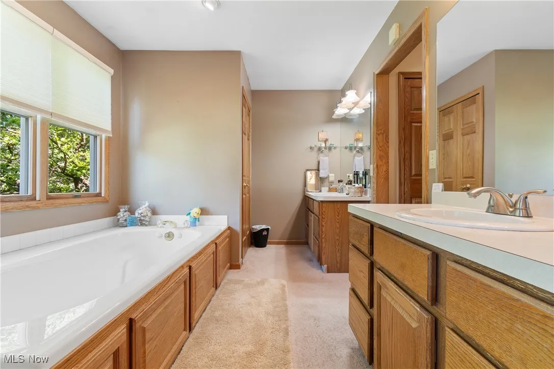 Bathroom featuring a bath and two vanities