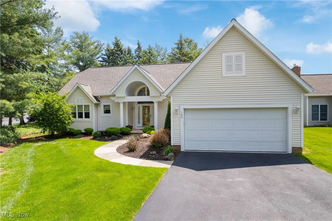 Traditional-style home with driveway, a front lawn, and roof with shingles