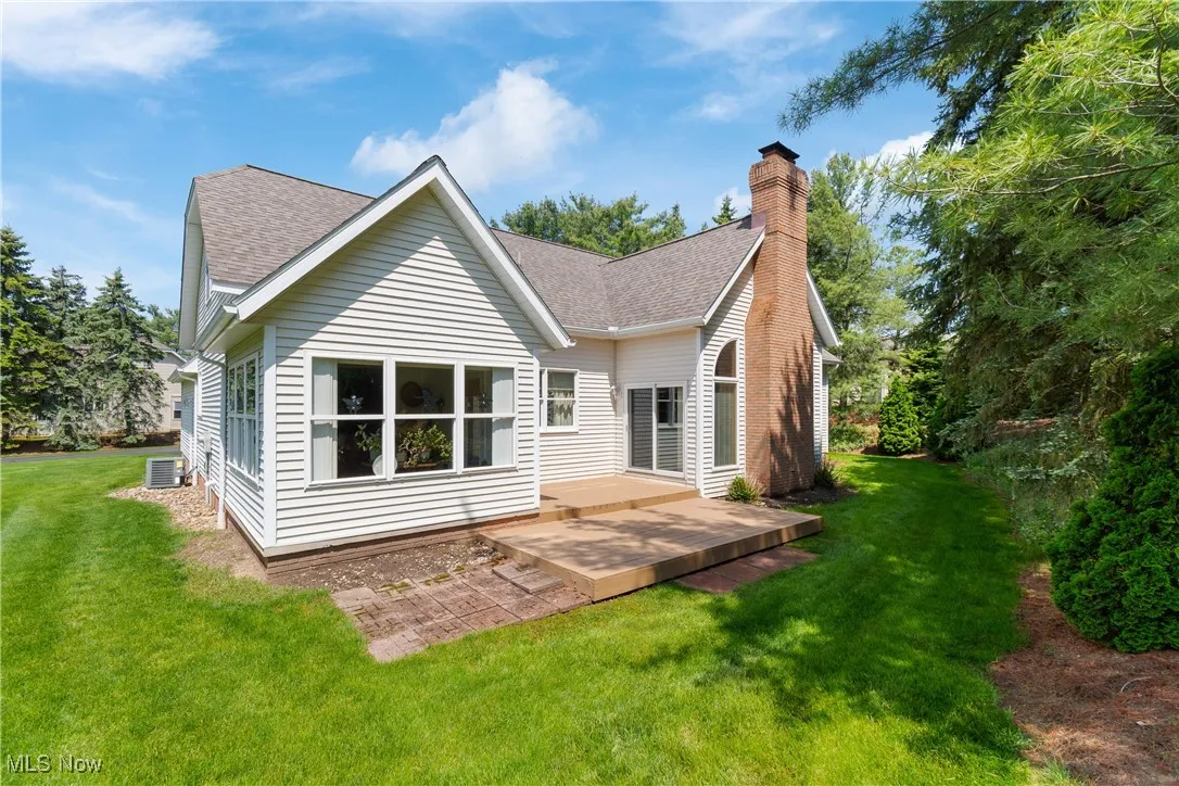 Rear view of property featuring a patio, roof with shingles, cooling unit, and a lawn