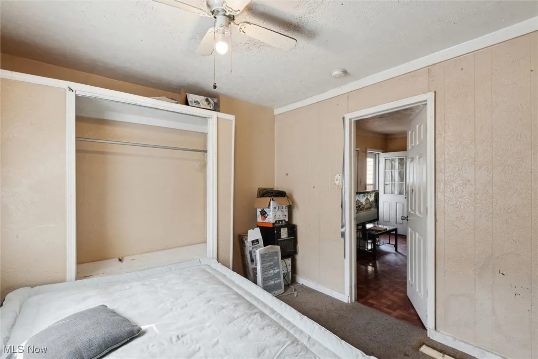 Bedroom featuring a textured ceiling, baseboards, and a ceiling fan
