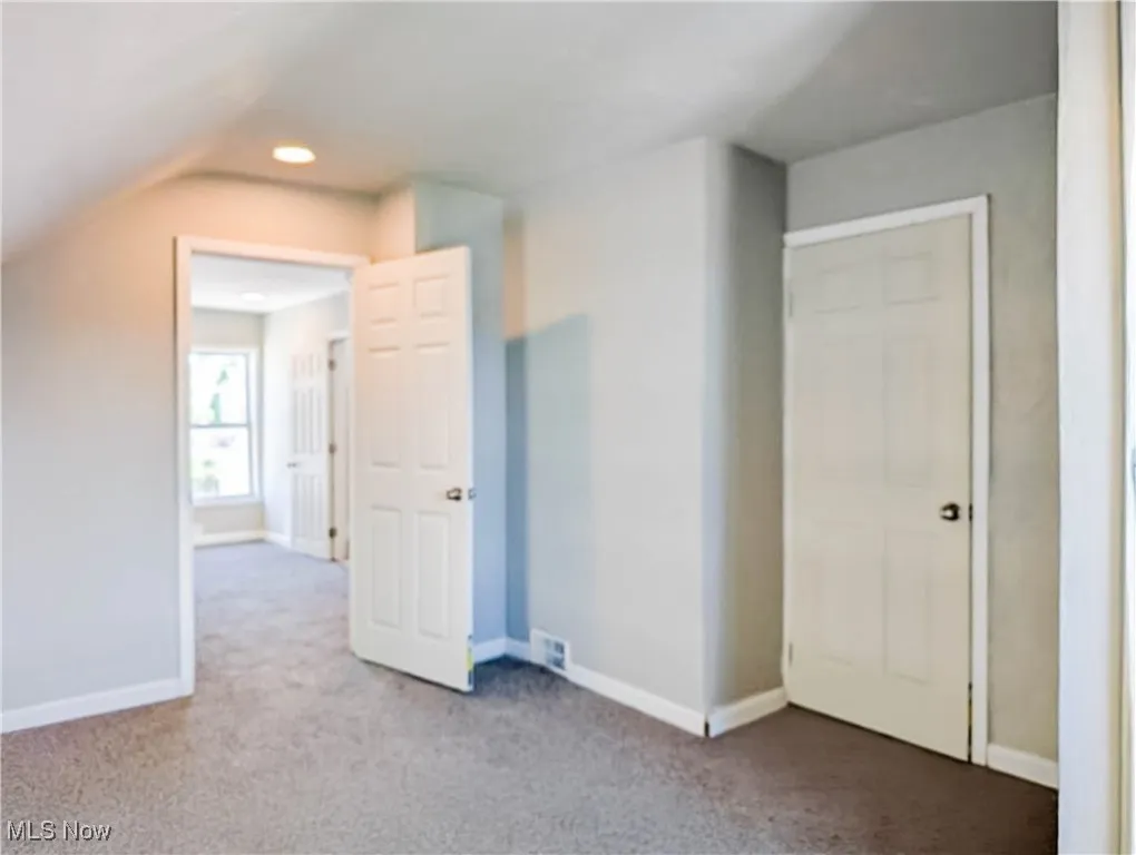 Bonus room with carpet floors, baseboards, and vaulted ceiling