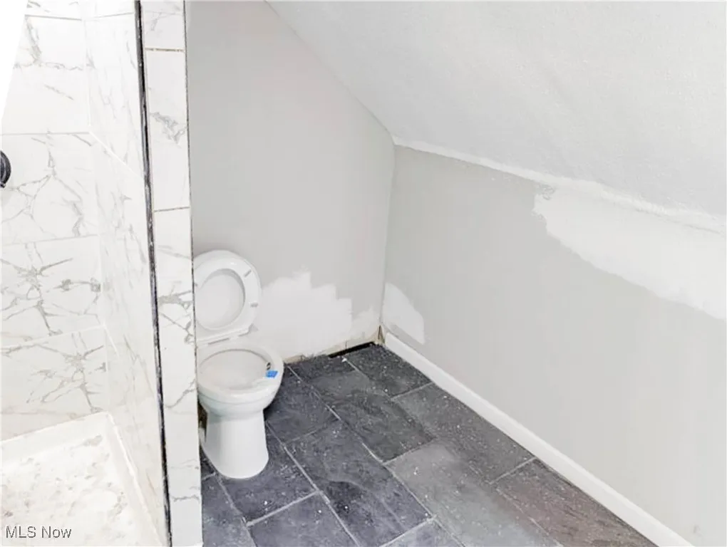 Full bath with a tile shower and toilet