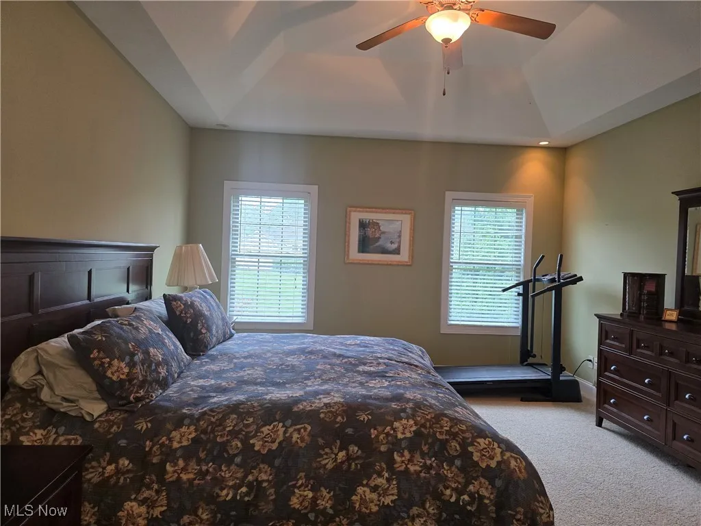 Carpeted bedroom featuring ceiling fan and baseboards