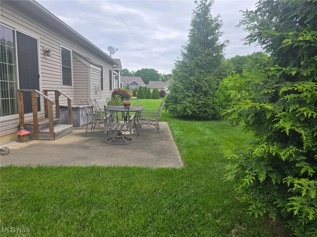 View of green lawn with a patio