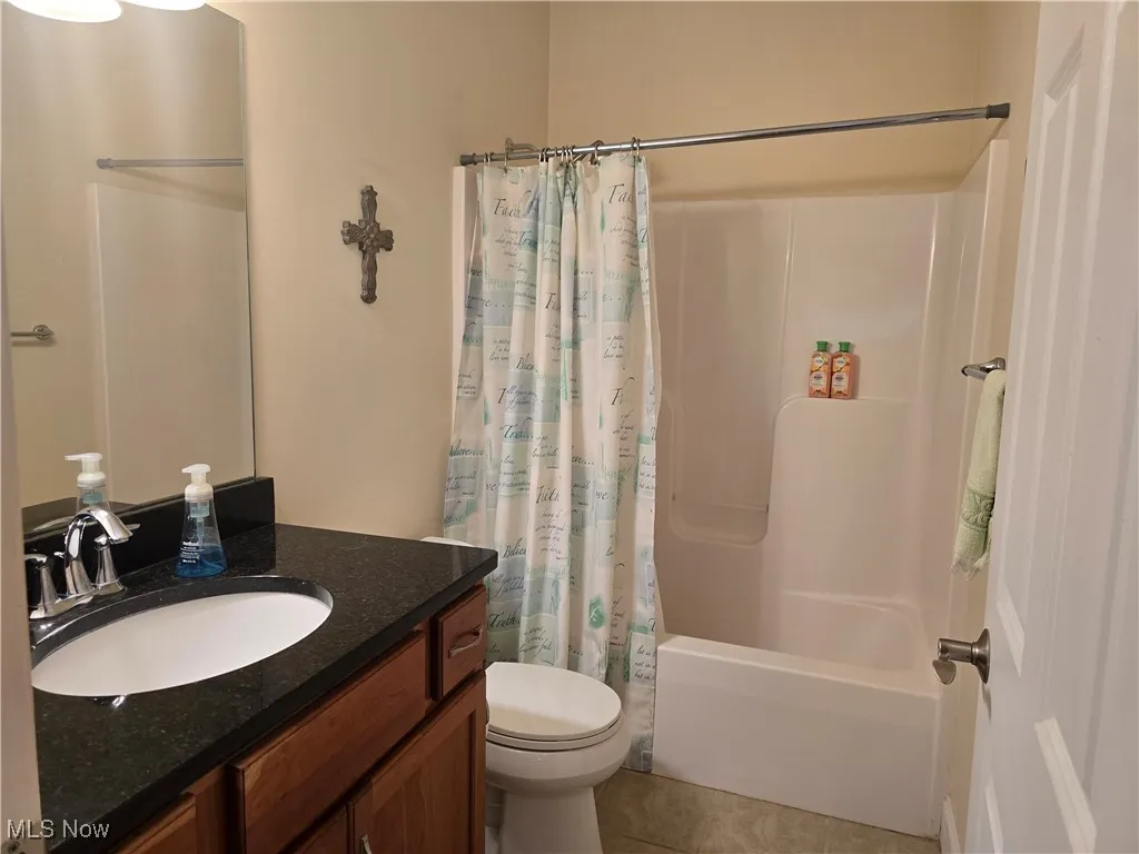 Main Bathroom featuring vanity, toilet, shower / bath combo with shower curtain, and tile patterned floors
